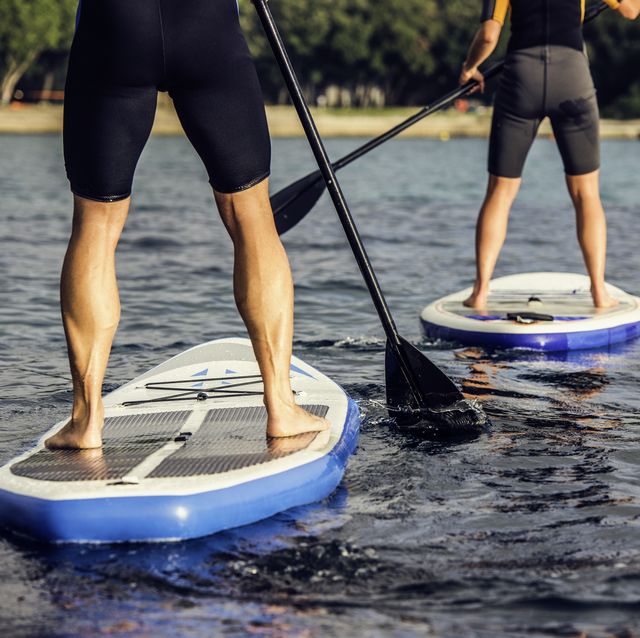 rear view of two paddle boarder's legs