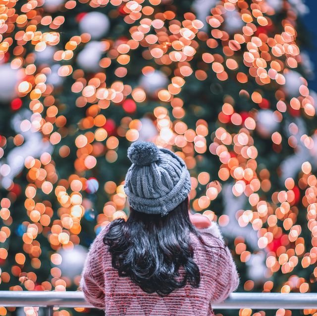 Rear View Of Woman Looking At Illuminated Christmas Lights