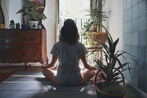 una mujer hace yoga en el salón de su casa