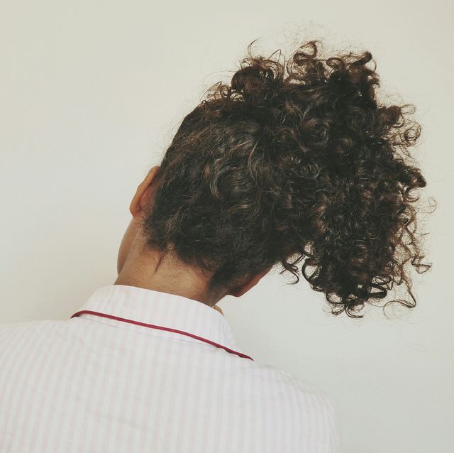 rear view of woman with curly hair against white background