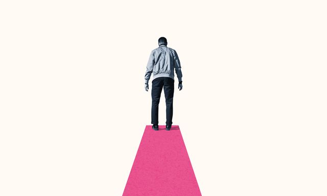 rear view of young man standing on pink footpath