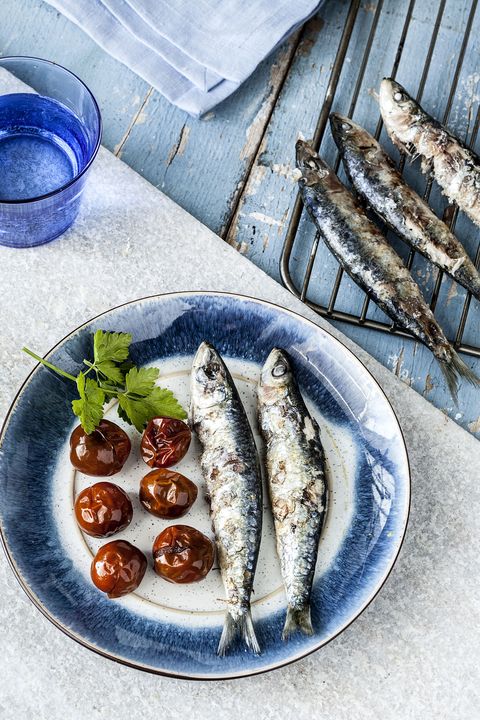 un plato de sardinas asadas con tomates al horno