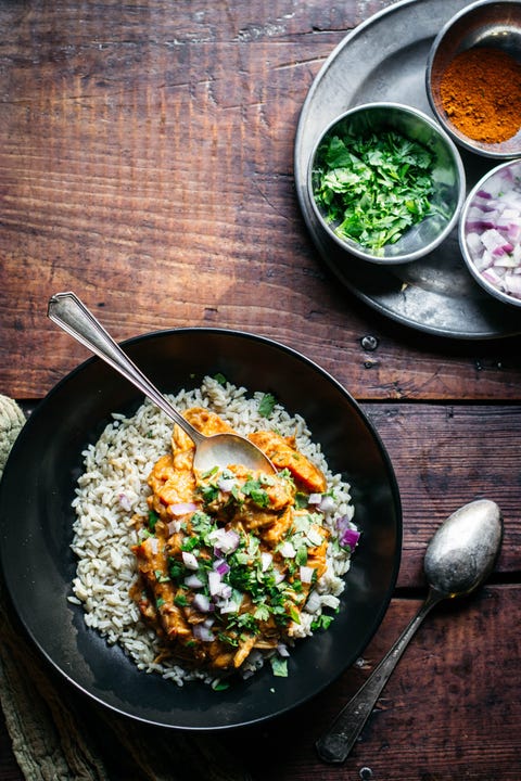 chicken tikka masala over rice in black bowl