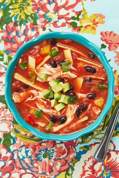 chicken tortilla soup with avocado garnish in blue bowl