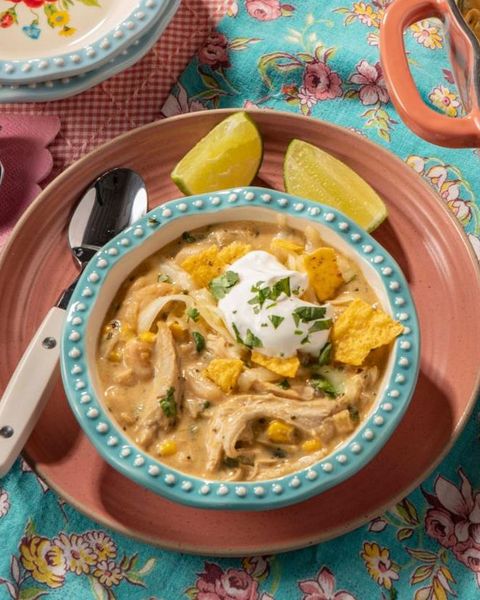 white chicken chili in blue bowl with sour cream and chips