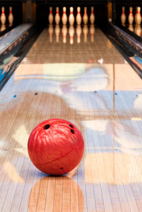 Red bowling ball sitting in middle of newly oiled lane Red bowling ball sitting in middle of newly oiled lane