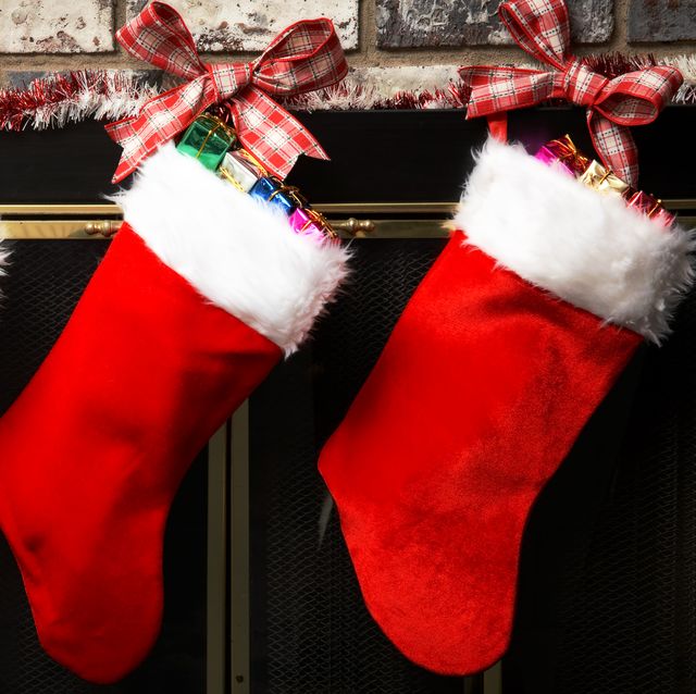 red christmas stockings hung up by tartan ribbon