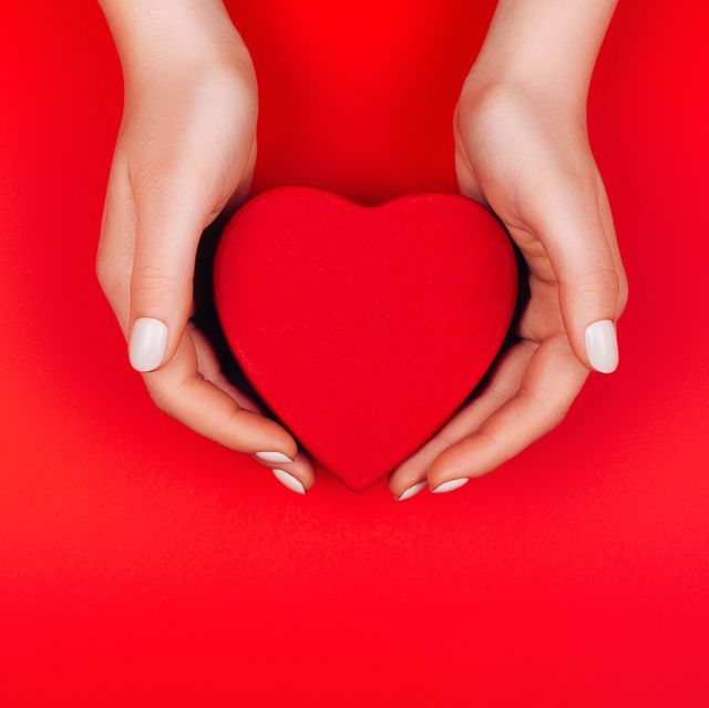red heart gift box in woman hands