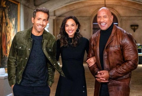 ryan reynolds gal gadot dwayne johnson holding arms smiling