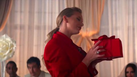 taylor quickly holding a red present in the music video i bet you think of me