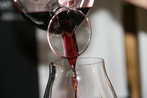 Vin rouge versé d'une carafe dans un verre à vin