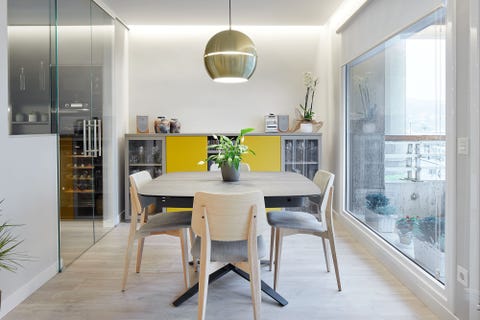 comedor de diseño moderno con mesa y sillas de madera y lámpara de techo dorada
