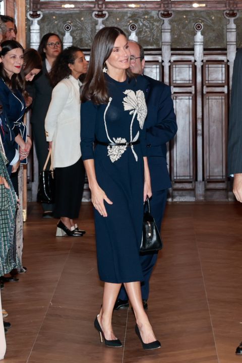 la reina letizia, en el bicentenario del ateneo de madrid, con u vestido de punto azul que dejaba entrever su sujetador