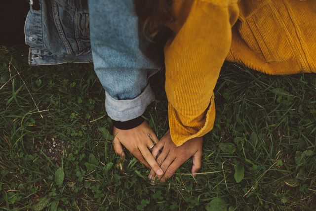 a couple holding hands on the grass