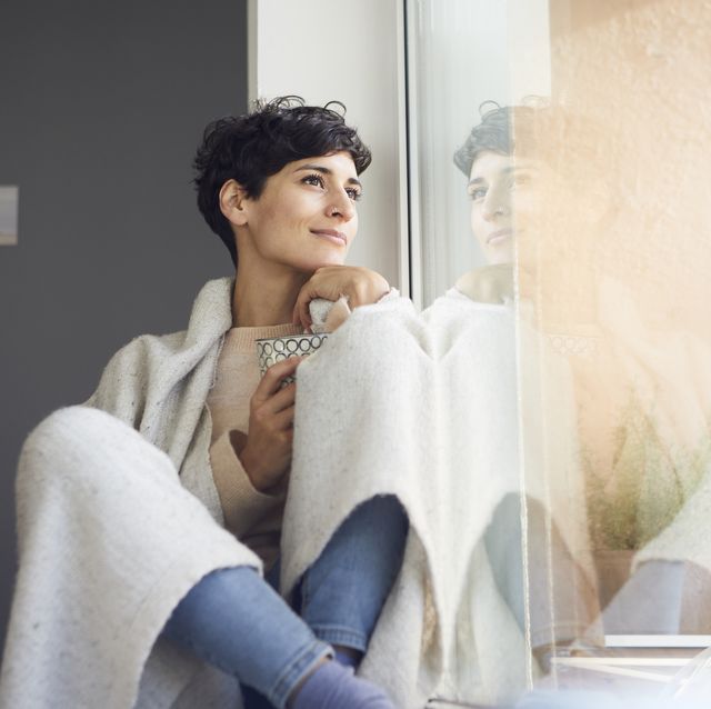 relaxed woman at home sitting at the window