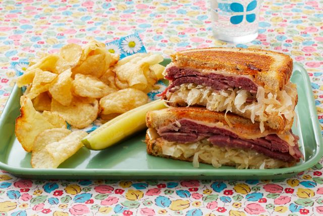 reuben sandwich with potato chips and pickles