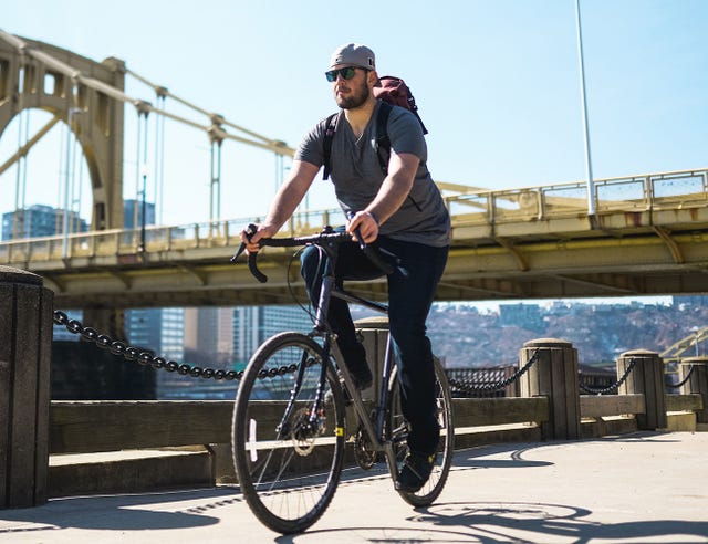man wearing dark medium revtown jean riding bicycle