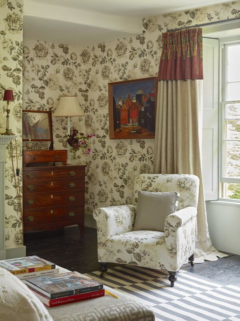 floral wallpaper covers the walls and chair is covered in matching fabric