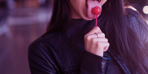 a person licking a lollipop