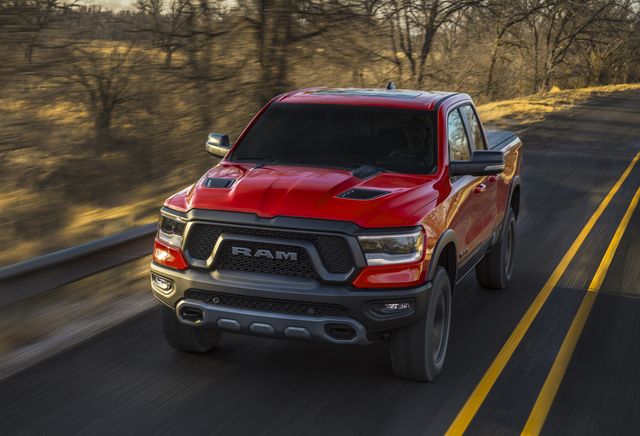 2022 ram 1500 rebel driving on a two lane highway with trees in the background