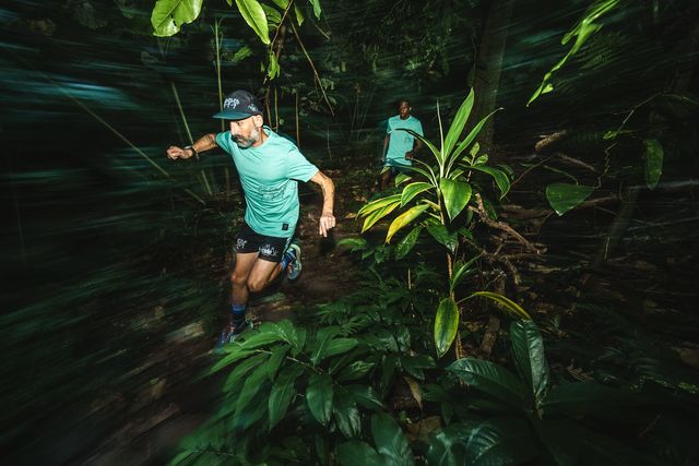 two men running through forest wearing roark shirts