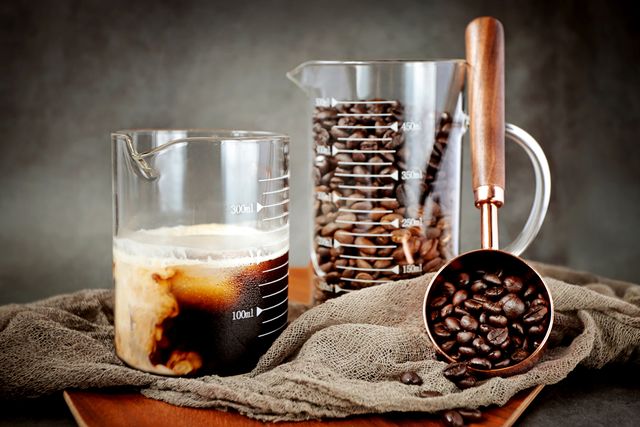 roasted coffee beans and coffee in a beaker