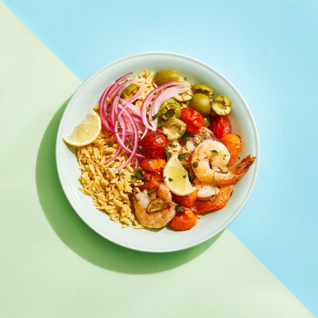 roasted mediterranean shrimp bowl with red onion, rice, tomatoes, olives and lemon