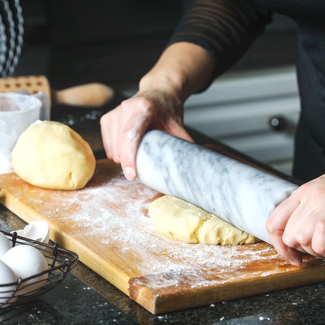person using marble rolling pin on dough