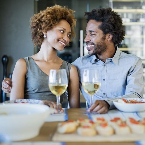 romantic black couple with wine glasses and appetizers