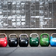 Row Of Kettlebells Against Wall At Gym row of kettlebells against wall at gym
