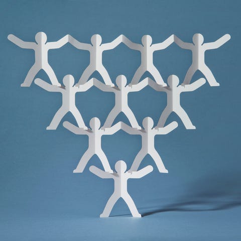 Rows of paper cut-out men balancing on one Rows of paper cut-out men balancing on one