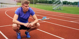 Runner resting on running track