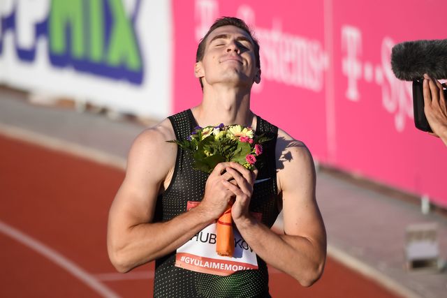 el atleta ruso shergey shubenkov celebra con un ramo de flores en la mano y mirando al cielo una victoria en 2018 en una carrera de 110 metros vallas