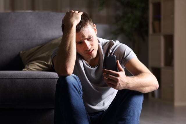 sad man checking mobile phone