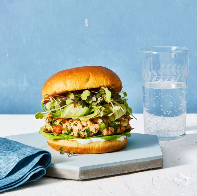 herby salmon burger with a glass of water