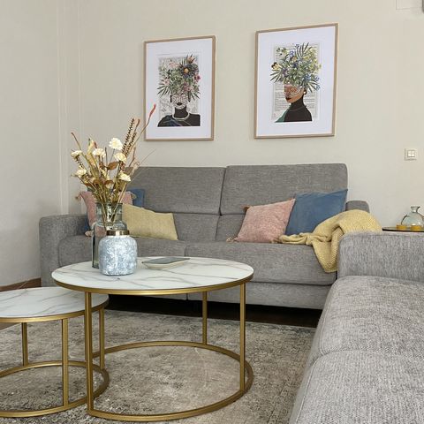 salón con sofá gris y mesa de centro dorada con sobre de mármol