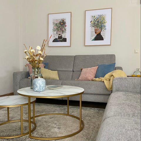 Salón con sofá gris y mesa de centro dorada con sobre de mármol salón con sofá gris y mesa de centro dorada con sobre de mármol