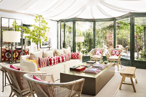 una casa de estilo british con jardín  sala de estar se ha creado acotando una zona del jardín con un cerramiento de cristal y aluminio verde carruaje