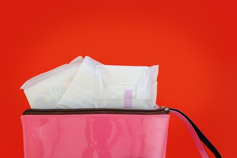 sanitary napkin in women's pink bag on red background