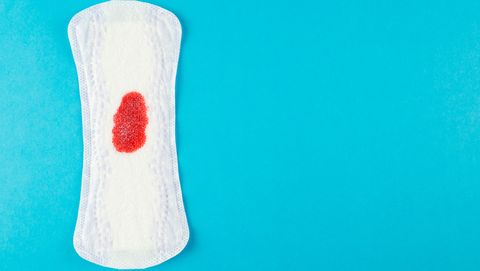 a sanitary pad with a blood stain on a blue background