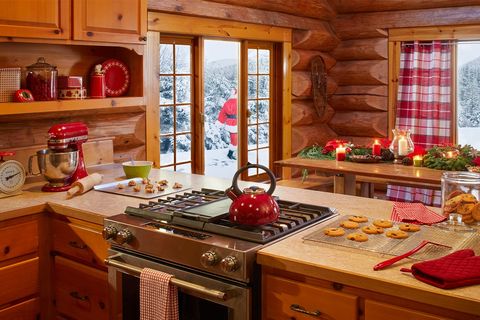 rustic natural wood kitchen with red accents, santa in snowy background seen through french doors