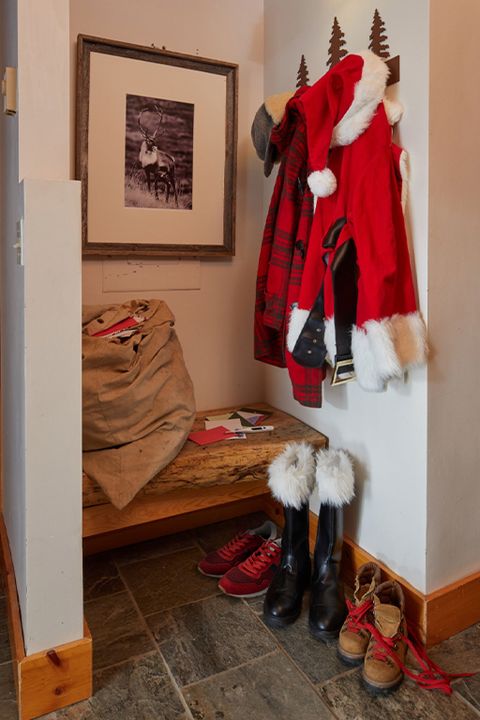 cubby with bench and reindeer photo on wall where santa stores his coat, hat, boots, and bag full of letters to santa