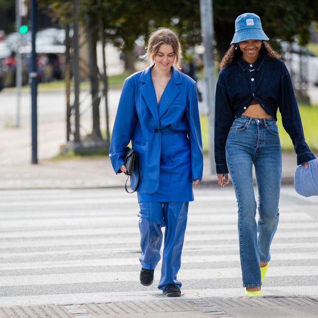 a woman walks at copenhagen fashion week wearing jeans