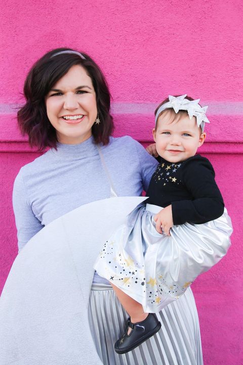 woman wearing crescent moon shape holding baby with stars on clothes and headband