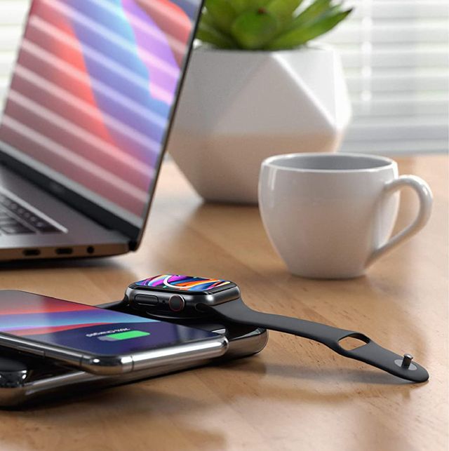apple watch charging with iphone on power bank next to laptop