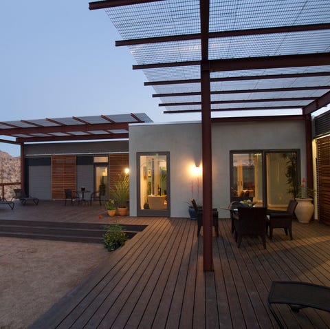 A scenic view of Joshua Tree is viewed from the site–built wood frame–living room connector which c