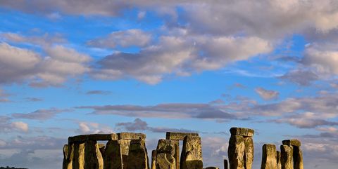 Scenic View Of Stonehenge In Field Against Cloudy Sky
