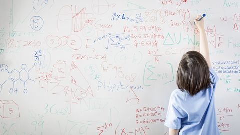 schoolgirl in front of wipe board, math equations