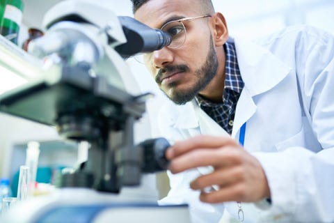 Scienziato al microscopio in laboratorio