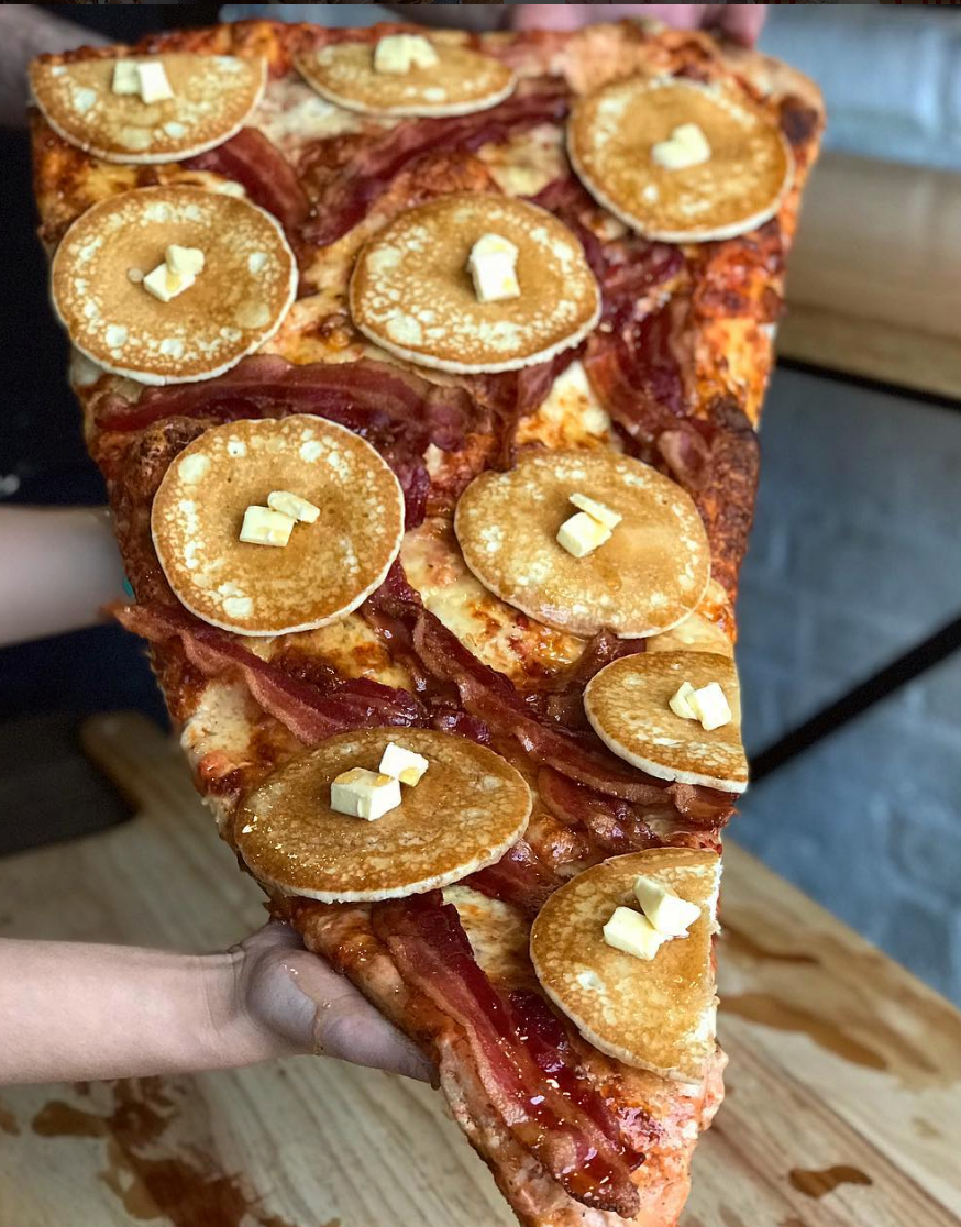 This Giant Pizza Slice Is Topped With Pancakes, Bacon, And 